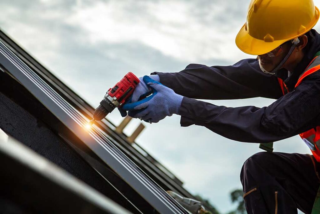 A homeowner compares a new asphalt shingle sample with weathered shingles on a residential roof.