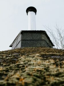 Uneven shingles and exposed flashing visible on a residential roof during a close inspection.